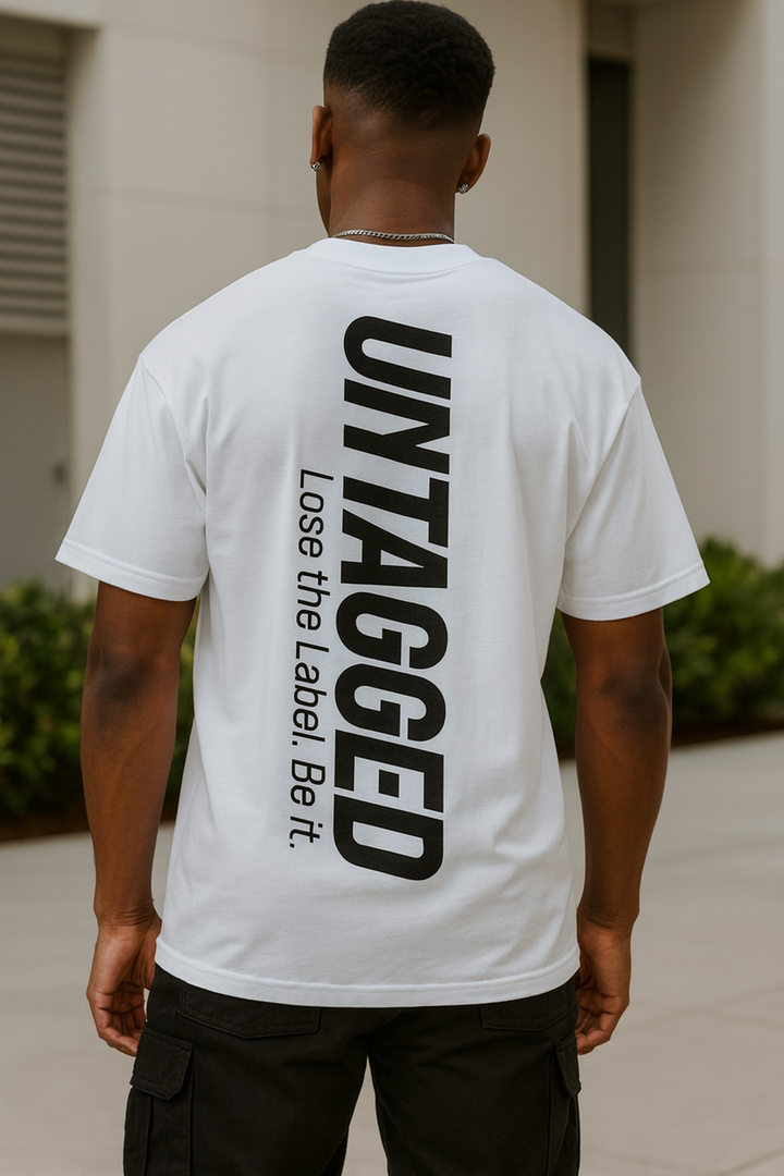 Person wearing a white t-shirt with 'UNTAGGED' text on the back, standing outdoors.