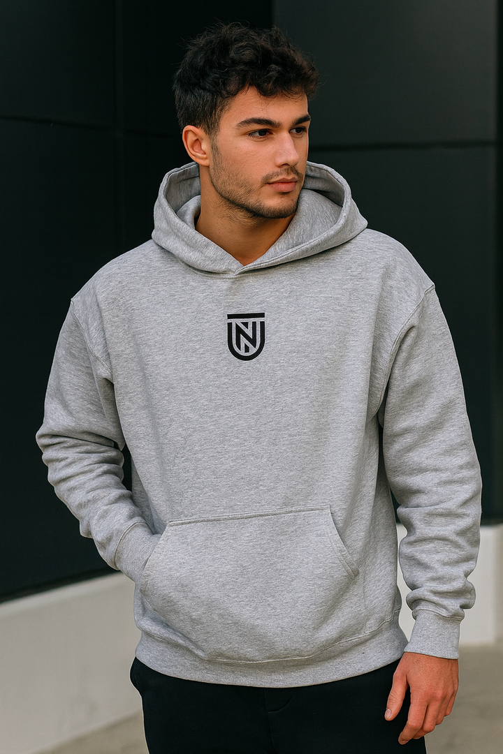 Man wearing a gray hoodie with a logo on a black background