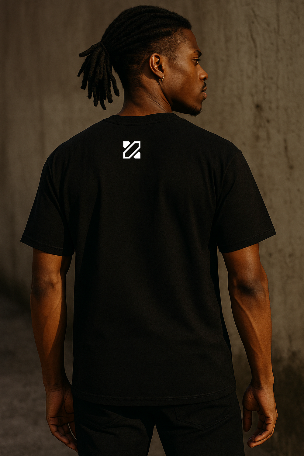 Person wearing a black t-shirt with a logo on the back against a brown background