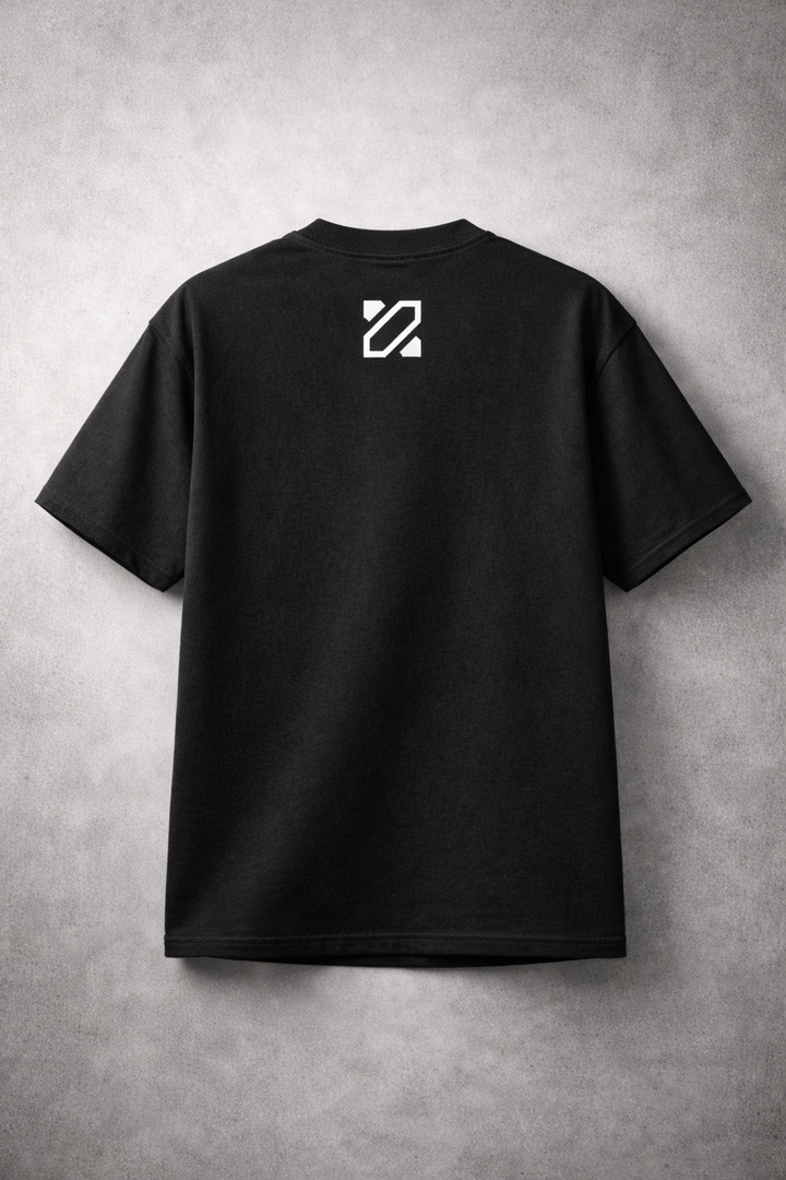 Black t-shirt with a white logo on the back against a gray concrete wall.