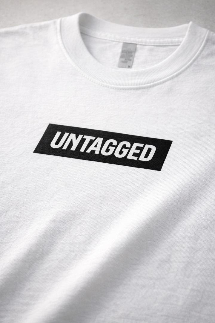 White t-shirt with 'UNTAGGED' label on a gray background