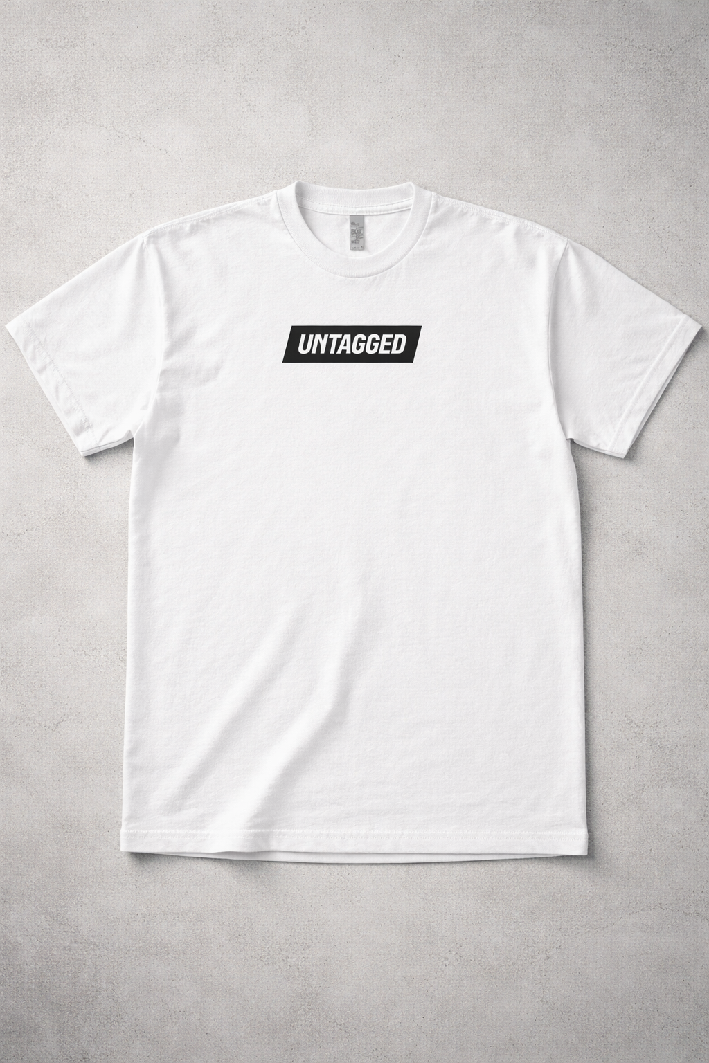 White t-shirt with 'Untagged' logo on a gray background